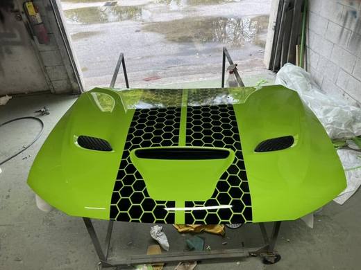 A Durango hood in bright green with a black honeycomb stripe, on the stand
