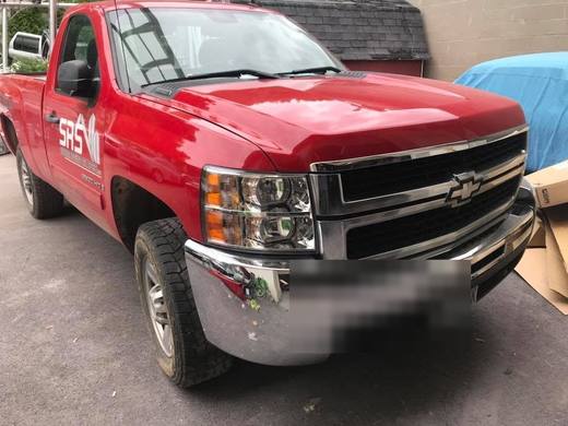 A red Silverado with the bumper back on