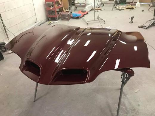 A maroon hood with twin scoops, freshly painted