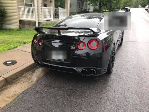 A black GT-R from the rear, wet ground