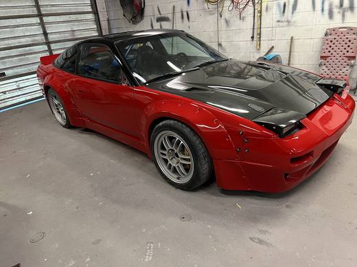 A red 240SX mid-build, panels off